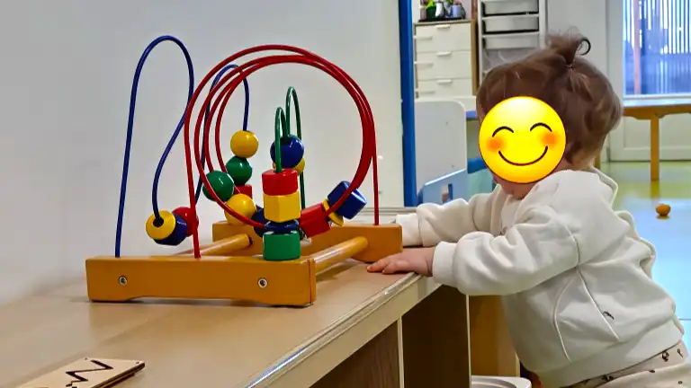 Enfant jouant avec un boulier Montessori à La Petite Crèche lors de la reprise des activités quotidiennes après les fêtes.